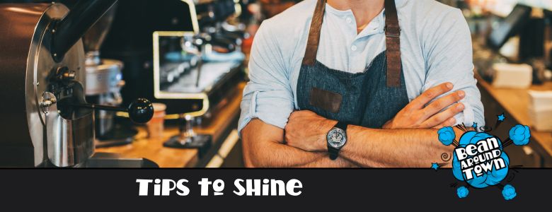 a barista folding over his arm in front of a coffee machine