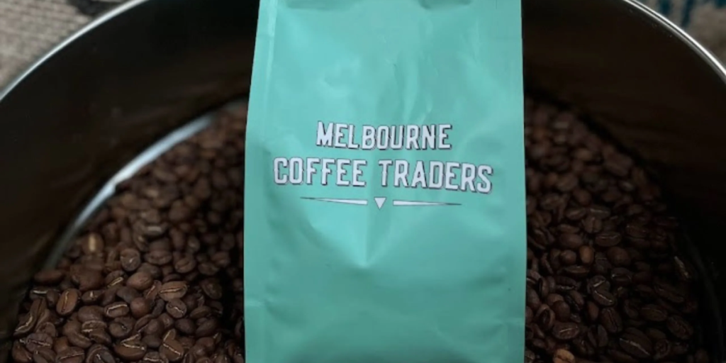 Melbourne Coffee Traders logo with a display of various coffee beans, representing a coffee bean supplier.