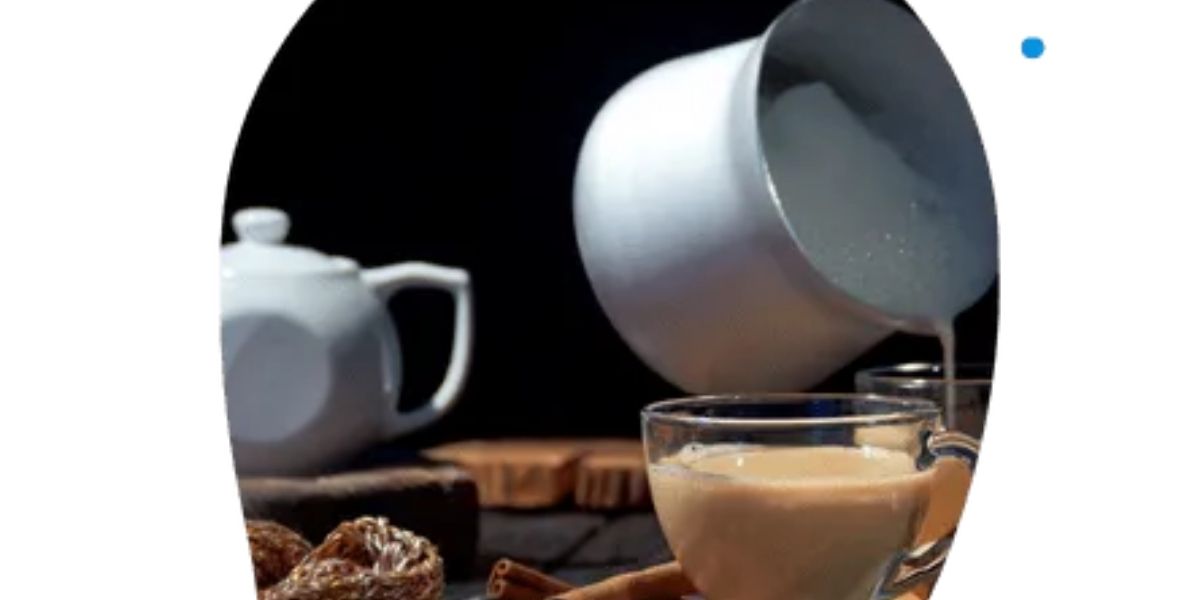 A cup of coffee beside a plate of assorted cookies, invitingly arranged on a wooden table.