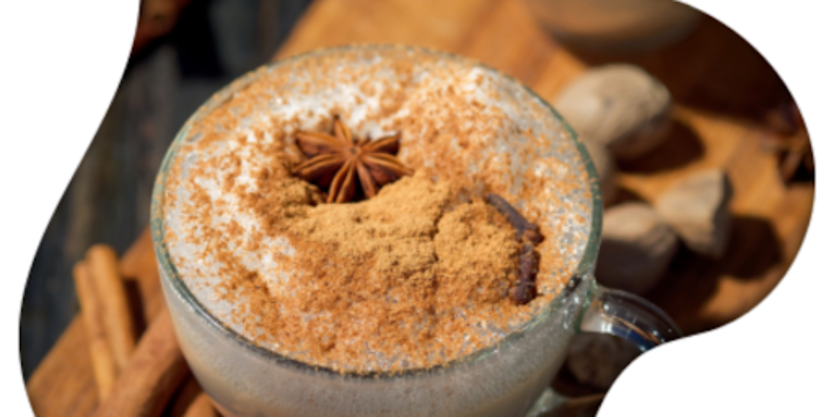 A glass of coffee topped with cinnamon and spices, showcasing a blend of traditional and modern chai influences.